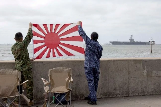 日本の戦犯旗を持っている米国兵士［写真　米海軍のＳＮＳ］