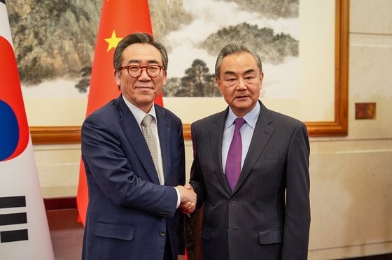 韓国外交部の趙兌烈長官と中国の王毅外相が１３日午後に中国・北京で開かれた韓中外相で握手している。［写真　韓国外交部］