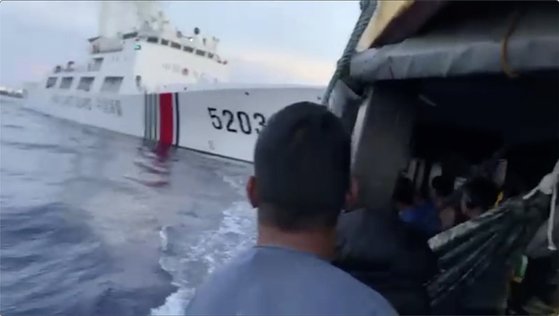 ５２０３の数字が書かれた中国海警局の船舶がフィリピンの補給船に接近する様子。［写真　フィリピン沿岸警備隊］