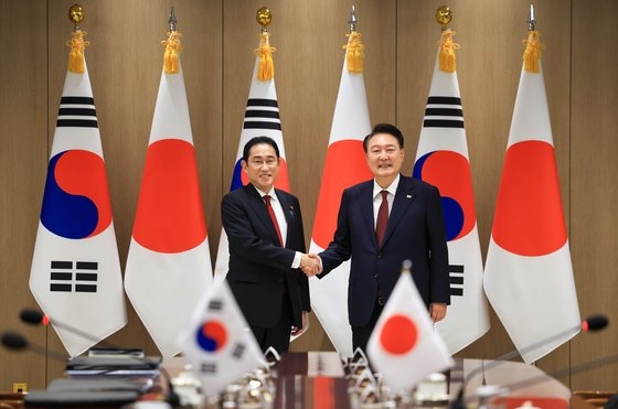 尹錫悦大統領が２６日、ソウル竜山の大統領室で開かれた日本の岸田文雄首相との会談に先立ち、握手をしている。［写真　大統領室］