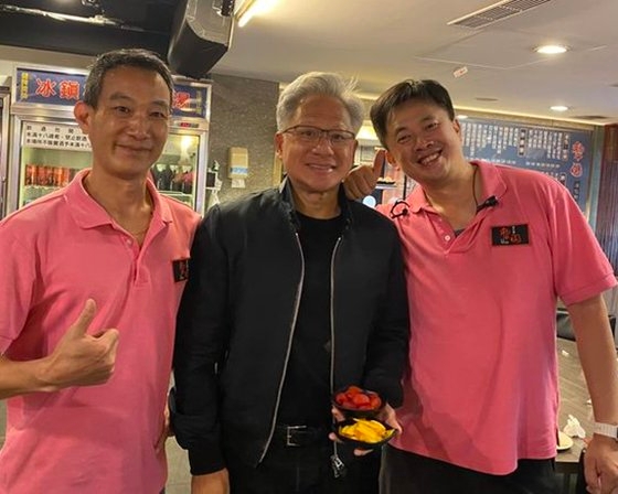 ２７日に台北の飲食店で従業員らと記念撮影するエヌビディアのジェンスン・フアンＣＥＯ（中央）。彼の資産価値は２８日現在１０００億ドル（約１５兆円）に上る。世界で１５番目の富豪だ。［フェイスブック　キャプチャー］