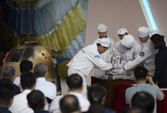  月で採取した土壌サンプルを確認する中国の研究陣。［写真　新華社通信＝聯合ニュース］