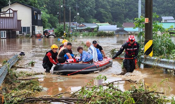 １０日午前、大田市西区龍村洞（テジョンシ・ソグ・ヨンチョンドン）の村に出動した救助隊員たちが、浸水で孤立した住民をゴムボートに乗せて救助している。フリーアナウンサーのキム・ソンテ