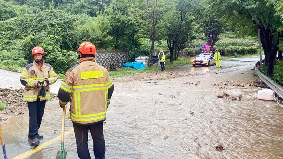 １４日午前７時３９分ごろ、慶尚南道巨済市一雲面（キョンサンナムド・コジェシ・イルンミョン）のある道路に土砂と石が降り注ぎ、消防当局が安全措置を取っている。［写真　慶南消防本部］