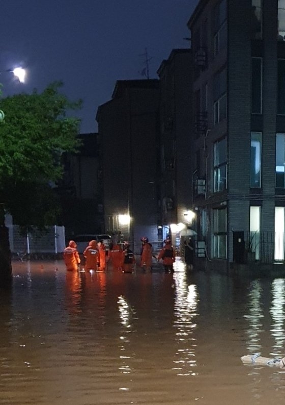 １８日未明、京畿道坡州市で道路が冠水し、消防当局が排水作業を行っている。［写真　京畿道北部消防災難本部］