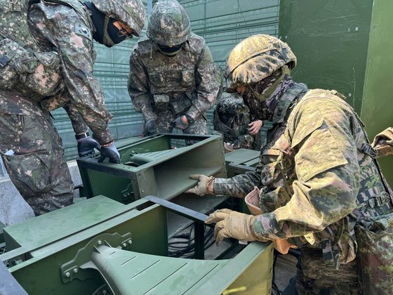 前方で拡声器を移動および設置する韓国の軍人　［写真　合同参謀本部］