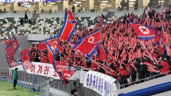 ２０２４パリオリンピック女子サッカーアジア最終予選の北朝鮮－日本戦を応援するため２月に東京国立競技場を訪れた朝鮮大学など朝鮮総連系列の応援団が「必勝朝鮮」と書かれたカードを持って応援している。　キム・ヒョンイェ特派員