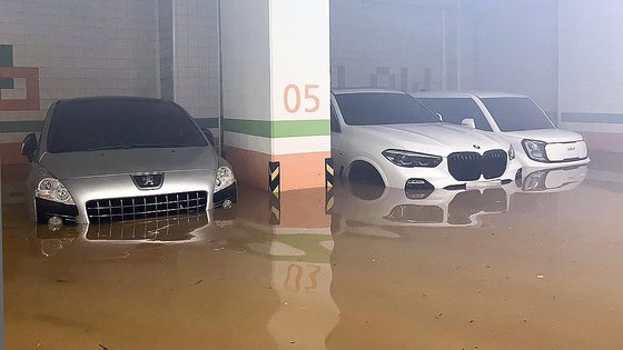 韓国南海岸に大雨が降った１６日午前、全羅南道莞島郡（チョルラナムド・ワンドグン）莞島邑のあるマンションの地下駐車場が浸水し、車の一部が泥水に浸かっている。［写真　莞島消防署］