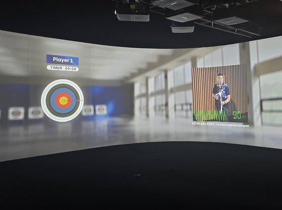 「モビリティー技術とアーチェリーの出会い」行事に傘下したオ・ジンヒョク選手。標的の右側の画面に「ビジョン基盤心拍数測定装置」で測定したオ・ジンヒョク選手の心拍数が表示されている。　オ・サム・グォン記者