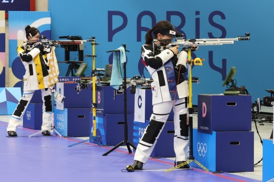 韓国選手団最年少の１７歳射手パン・ヒョジンは中国の黄雨婷（左）と延長シュートオフの接戦の末に生涯初のオリンピック（五輪）金メダルを首にかけた。キム・ソンリョン記者