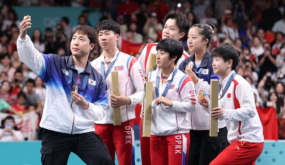 卓球混合ダブルスの授賞式で記念撮影する韓国と北朝鮮の選手たち［写真　聯合ニュース］