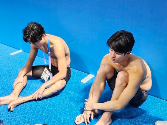 李昊峻（左）と黄宣優がパリ五輪リレー８００ｍ決勝を終えた後取材エリアでのインタビューを終え座り込んでいる。コ・ボンジュン記者