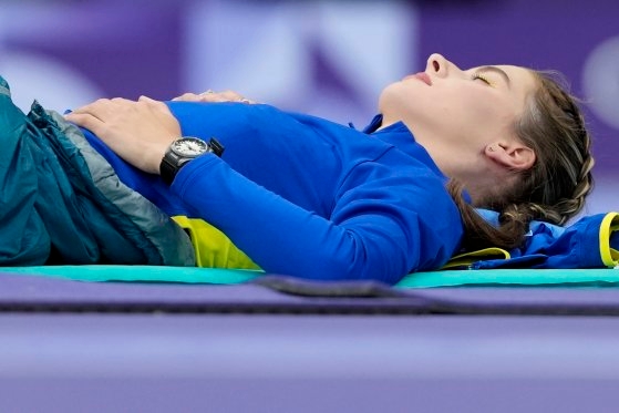 目を閉じたまま休んでいるウクライナの走り高跳び選手［写真　ＡＰ＝聯合ニュース］