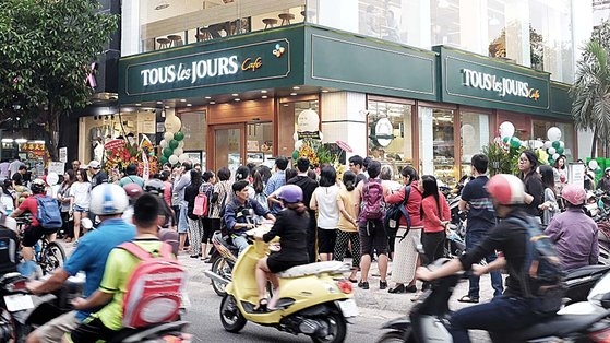 韓国のベーカリーチェーン「トゥレジュール（Ｔｏｕｓ　Ｌｅｓ　Ｊｏｕｒｓ）」ベトナム・カンホイ店開店当時、客が店舗を訪問するために列に並んでいる様子。 ［写真　ＣＪフードビル］