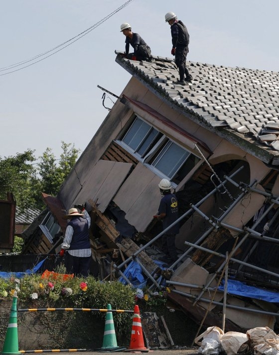 地震で倒壊した住宅で救助活動を行う人々。［写真　ロイター＝聯合ニュース］