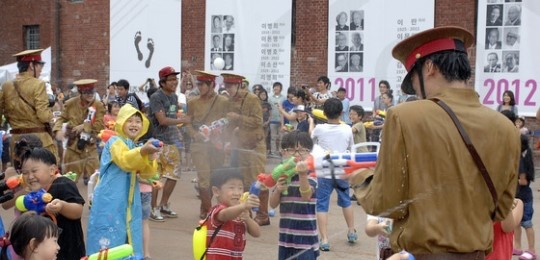 西大門刑務所で日本巡査姿の男性に水鉄砲を撃つ子供たち［写真　西大門区］