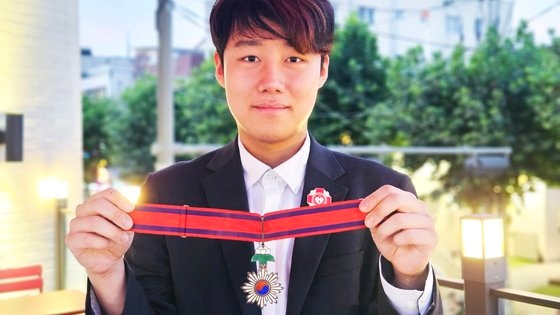 ８日、ソウル西大門区延禧洞（ソデムング・ヨニドン）のカフェで延世大学在学生のイ・ギュインさん（２１）が大韓帝国勲三等太極章を手に持って見せている。イさんは昨年１０月、オンライン骨董品取引サイト（ｅ－Ｍｅｄａｌｓ）で開かれた競売に参加し、５０００ドルで太極章を落札した。イ・ヨングン記者