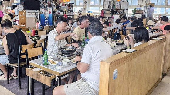 ２１日午後２時３０分ごろ、釜山チャガルチ市場２階の食堂。平日昼の時間にも韓国人、外国人の客で賑わっていた。最近は海外からの個人旅行客がよくチャガルチ市場を訪れているという。　キム・ミンジュ記者