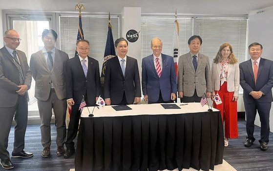  韓国宇宙航空庁とＮＡＳＡ関係者が協約式後に記念撮影をしている。左からジェームズ　フリーＮＡＳＡ宇宙探査システム本部長、チョン・グァンウ宇宙航空庁国際協力担当官、イ・サンリュル航空宇宙研究院長、尹寧彬宇宙航空庁長、ビル・ネルソンＮＡＳＡ長官、パク・ヨンドゥク韓国天文研究院長、カレン・フェルドスタインＮＡＳＡ国際協力局長、ジョン・リー宇宙航空庁本部長。［写真　韓国宇宙航空庁］