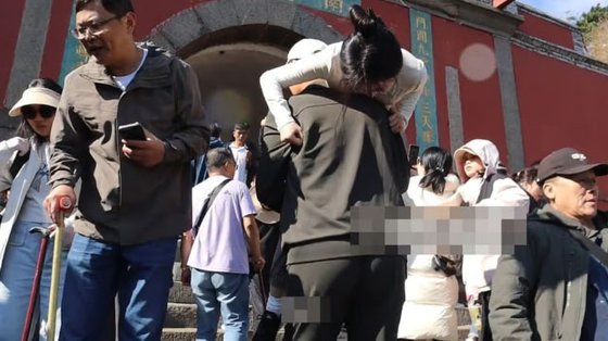 インフルエンサーを担いで泰山を登る登山支援員［写真　抖音］