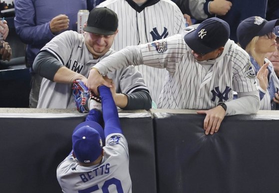 試合中に選手のグローブからボールを奪おうとするヤンキースのファン［写真　ＵＰＩ＝聯合ニュース］