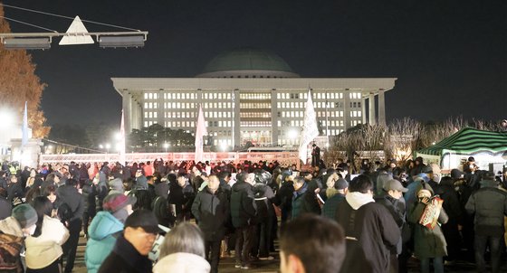 尹錫悦大統領の非常戒厳解除要求決議案が国会本会議で可決された４日未明、ソウル汝矣島（ヨイド）の国会正門前に集まった市民たちが尹大統領を糾弾している。チョン・ミンギュ記者