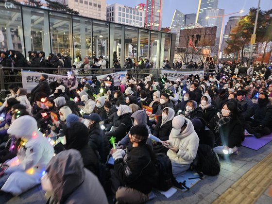 ８日午後５時、ソウル汝矣島（ヨイド）の国会議事堂駅近くで行われた「尹錫悦大統領弾劾集会」に参加した市民たちがプラカードを持っている。手に色とりどりのコンサート用ペンライトを持った人々が見える。シン・ヘヨン記者