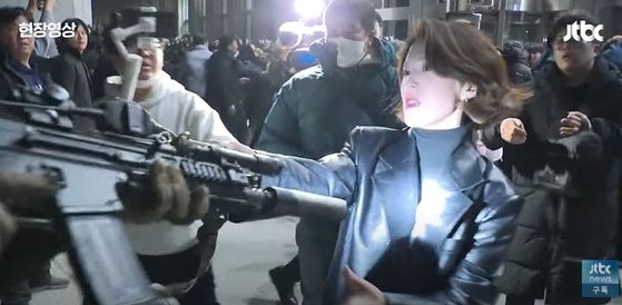 国会議事堂に入った戒厳軍の銃口をつかんで立ち向かう韓国野党の安貴朎報道官［ＪＴＢＣ　キャプチャー］