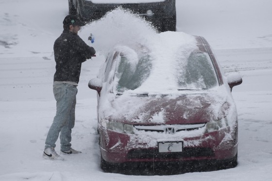 車に積もった雪を片付けるシンシナティ市民［写真　ＡＰ＝聯合ニュース］