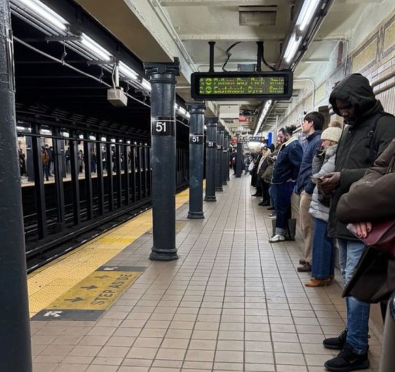 地下鉄ホームの壁にくっついて列車を待っているニューヨーク市民［写真　Ｘ］  ​