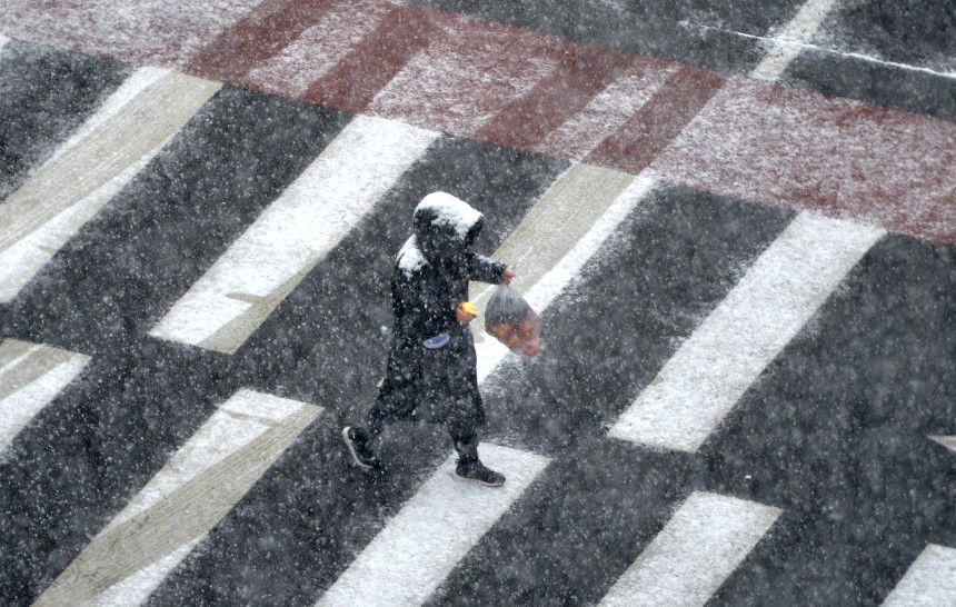 ある市民が雪に当たりながら道を歩いている。フリーランスのキム・ソンテ