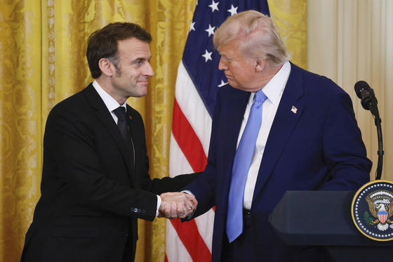 握手をしているトランプ大統領とマクロン大統領。［写真　ＡＰ＝聯合ニュース］