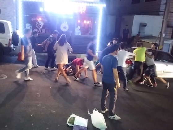 飲食店の女性店主を集団暴行する中国人たち。［写真　済州西部警察署］