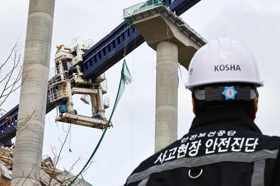 安全保健公団の関係者らが２５日、京畿道安城市のソウル世宗高速道路天安－安城区間連結工事の高架橋崩落事故現場を見ている。　キム・ジョンホ記者