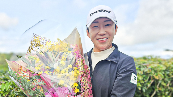 ＪＬＰＧＡ生涯獲得賞金１位を達成した直後、祝賀花束を懐に抱いて笑顔を見せる申智愛（シン・ジエ）。［写真　申智愛］