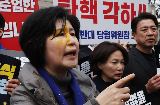 キャプション＝卵を顔にぶつけられた共に民主党議員［写真　ニュース１］