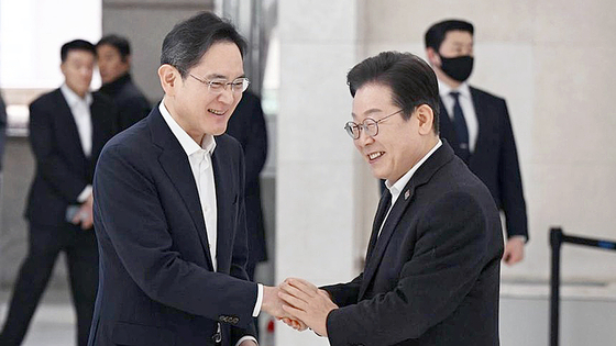 「共に民主党」の李在明代表が２０日、サムスン青年ソフトウエアアカデミーで開かれた青年就業支援に向けた現場懇談会に先立ち出迎えたサムスン電子の李在鎔会長とあいさつしている。［写真　共同取材団］