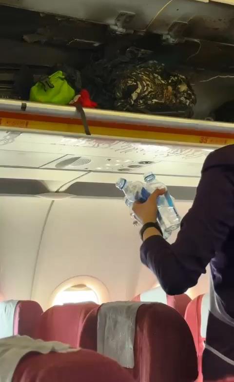 ミネラルウォーターで旅客機内の火災を鎮火する様子。［写真　ＳＮＳ］  ​