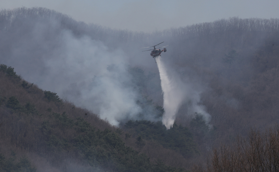 慶尚南道山清郡（キョンサンナムド・サンチョングン）で２１日に発生した山火事鎮火作業が３日間続いている中、２３日、矢川面（シチョンミョン）でヘリが水を撒いて鎮火している。ソン・ポングン記者。
