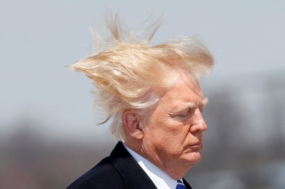 風によって髪の毛が乱れているトランプ大統領。［写真　ロイター＝聯合ニュース］