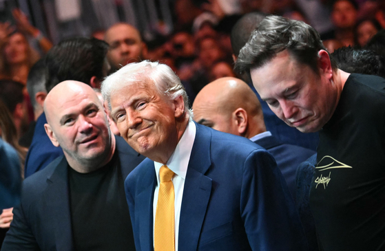 ＵＦＣ開催場を訪れたトランプ大統領。ホワイトＵＦＣ会長が案内した。右はイーロン・マスク・テスラＣＥＯ。［ＡＦＰ＝聯合ニュース］