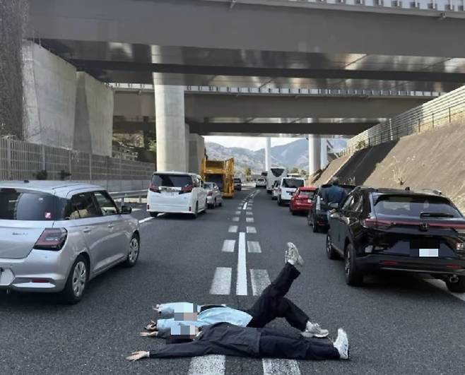 ​日本のある高速道路で観光バス衝突事故で交通が停滞する時間を利用して高速道路の上に横になり、いわゆる「人生写真」を撮影した中国人女性たちが非難されている。［写真　Ｘ］