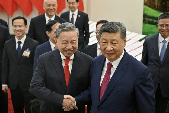 中国の習近平国家主席が１４日（現地時間）、ハノイの党中央委員会事務室でベトナムのトー・ラム共産党書記長との会談を終え、中国とベトナムが締結した協定の写本を見て握手をしている。［ロイター＝聯合ニュース］