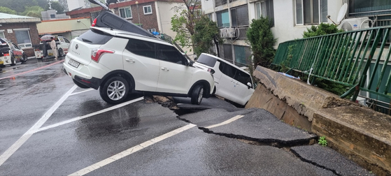 ２２日午後、京畿道南揚州華道邑で団地の駐車場の擁壁が崩れ、数台の車が破損した。　［写真　京畿北部消防災難本部］