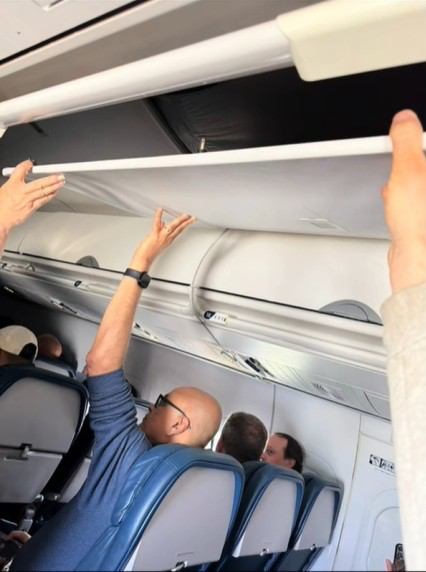 落ちた航空機の内部の天井を乗客が支える様子。［写真　ＳＮＳ］　