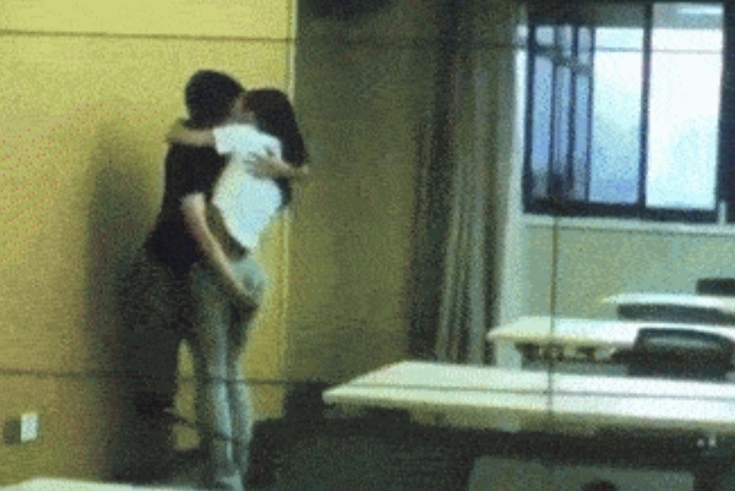 空いた会議室で抱き合っている男女職員。［写真　中国ネットイース］