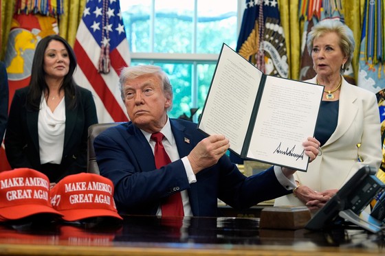 ドナルド・トランプ大統領が２３日（現地時間）、ホワイトハウスで黒人および少数人種に対する学校の配慮を「人種差別」と規定する内容の行政命令に署名した後、これを手にして見せている。［写真　ＡＰ＝聯合ニュース］