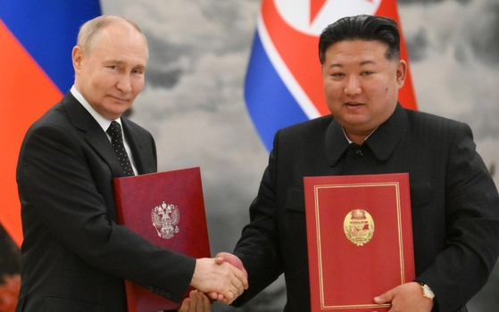 北朝鮮の金正恩（キム・ジョンウン）国務委員長とロシアのプーチン大統領（左）は昨年６月、包括的戦略パートナーシップ条約に署名し、条約文を交換した。［ＥＰＡ＝聯合ニュース］