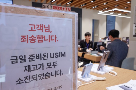 ＵＳＩＭ（加入者識別モジュール）情報を奪取されたＳＫテレコム（ＳＫＴ）がＵＳＩＭ無料交換サービスを開始した２８日、ソウル市内あるＳＫＴショップにＵＳＩＭ在庫が無くなったことを知らせる案内が設置されている。［写真　聯合ニュース］