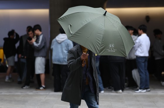 ソウルに雨が降った１日午前、ソウル中区（チュング）の東大門（トンデムン）デザインプラザ（ＤＤＰ）付近で雨宿りをする市民の様子。［写真　聯合ニュース］